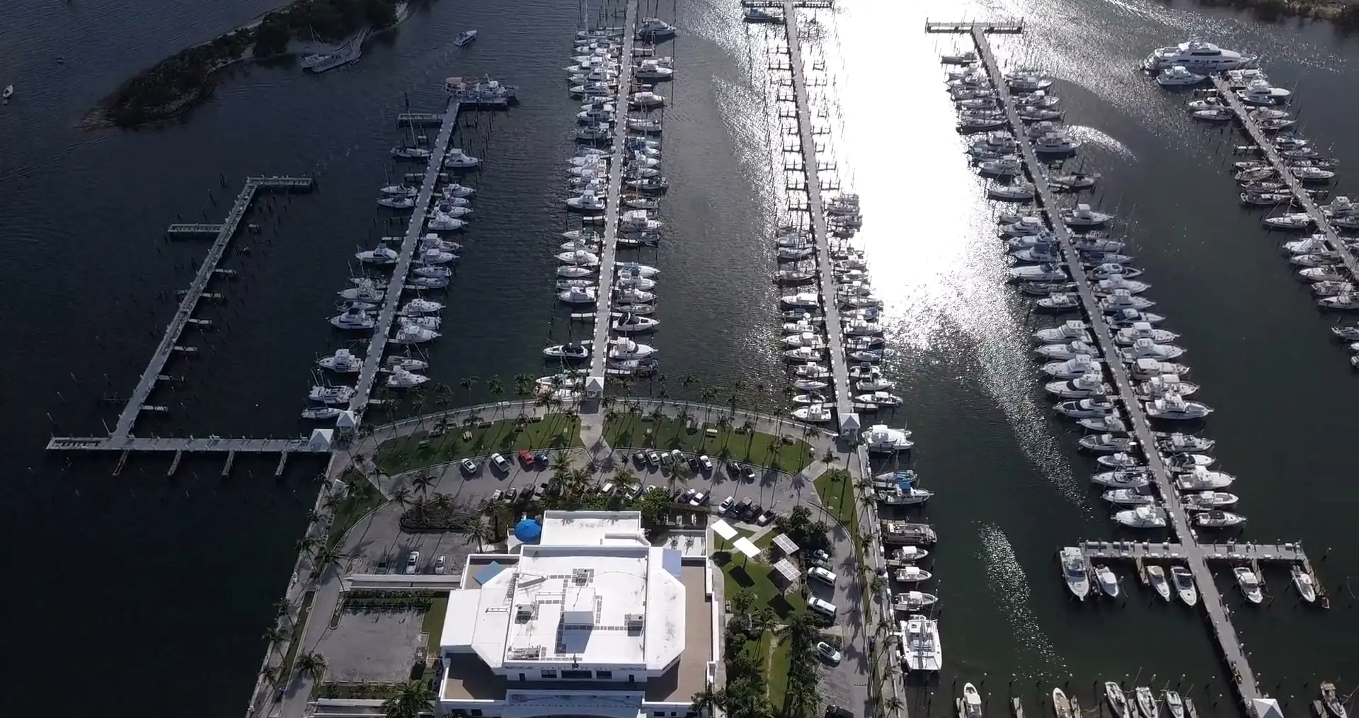 Top-down aerial view of a marina (the stock page tags it Miami): rows of moored boats and sun on the water.